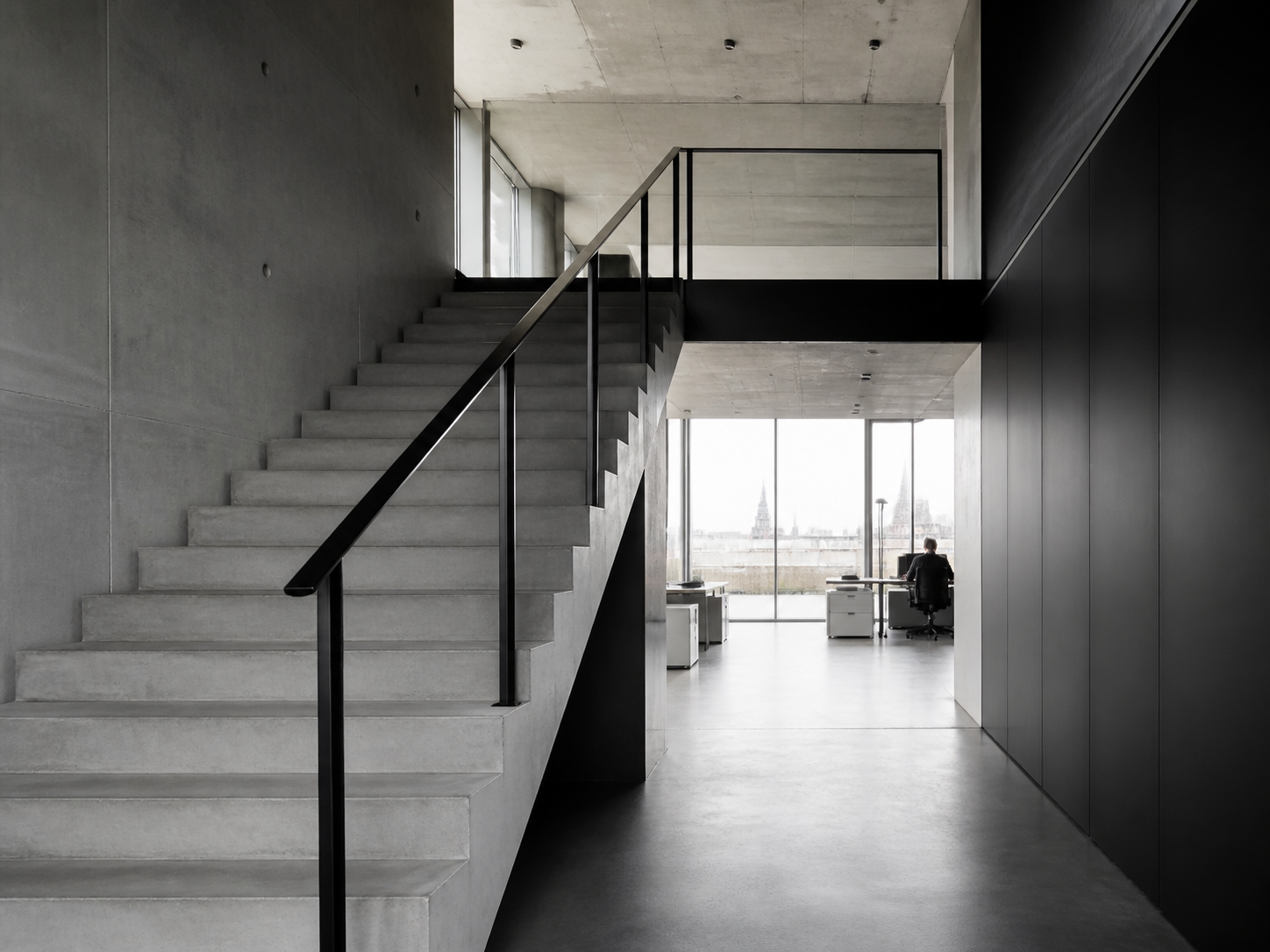 Minimal concrete staircase and workspace in a modern office